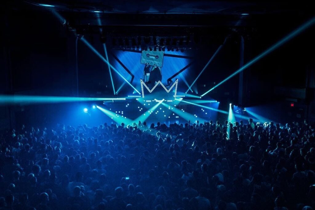 Vibrant nightclub scene with a crowd enjoying the dynamic light show at a rave party.