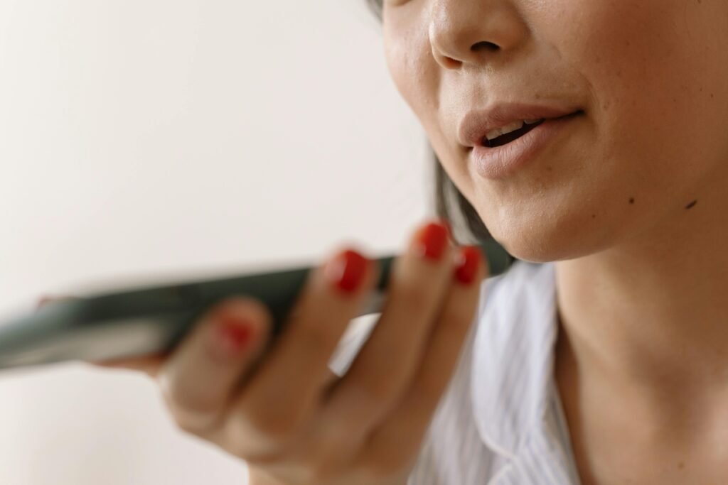Close-up of a woman using smartphone voice command, showcasing technology and communication.